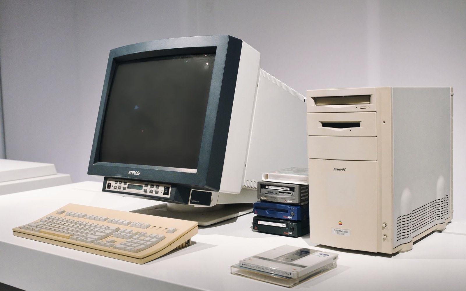 Vintage Power Macintosh tower computer with monitor, keyboard, and external drives on display
